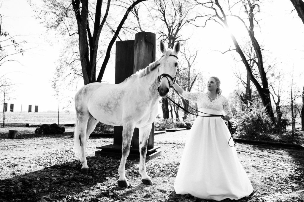 Mariée dans les jardins, photoshoot mariage avec un cheval aux Portes des Iris.